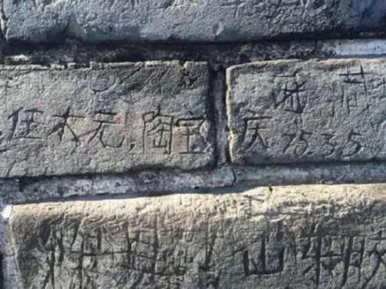 3名游客“接力”在八达岭长城上刻字